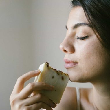 Profile of a woman enjoying the scent of handmade soap in a calm studio setting.